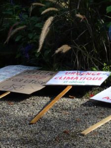 Des panneaux de manifestants, au sol, l'un indique "Urgence climatique"
