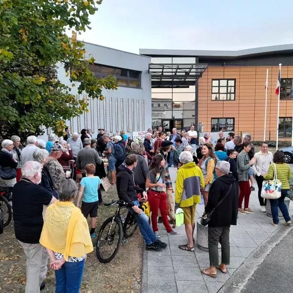 Plan large du rassemblement du 10 octobre 2023. On dénombre environ 80 participants de tout âge. La photo contient aussi un vélo et un chien en laisse. Tout le monde est calme et souriant.